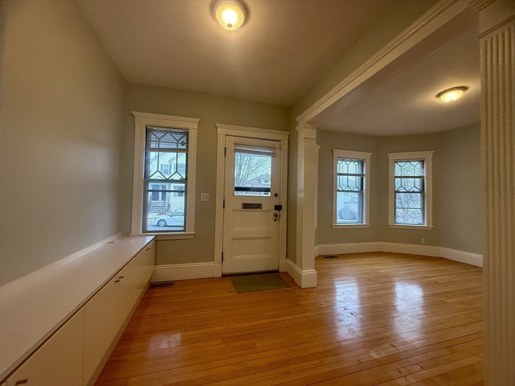 172 Maplewood Street, Unit 172 Watertown, MA 02472 - Photo 7 of 29 a view of an empty room with a window and wooden floor