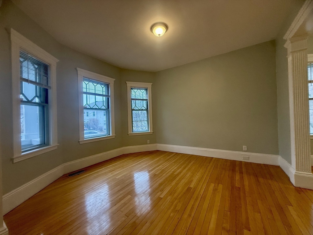 172 Maplewood Street, Unit 172 Watertown, MA 02472 - Photo 9 of 29 a view of an empty room with wooden floor and a window