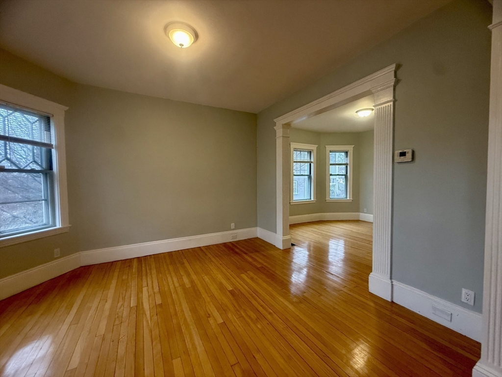172 Maplewood Street, Unit 172 Watertown, MA 02472 - Photo 10 of 29 an empty room with wooden floor and windows