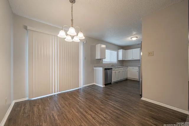 a view of a kitchen with a sink a cabinet a refrigerator and cabinets