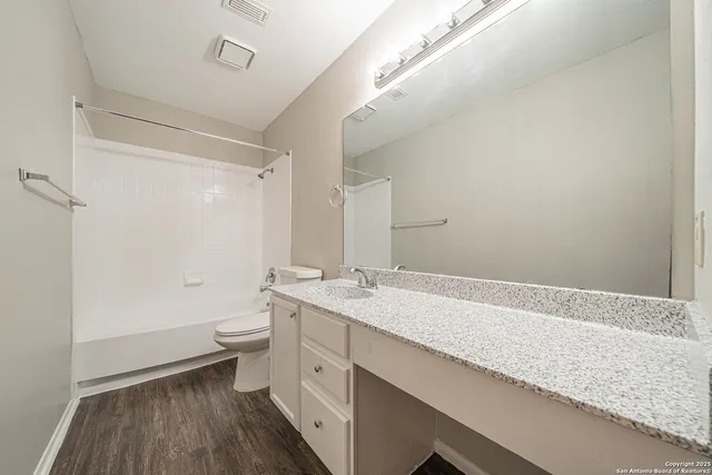 a white toilet sitting next to a bath tub