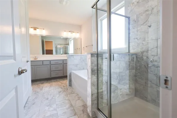 a bathroom with a granite countertop sink mirror and bathtub
