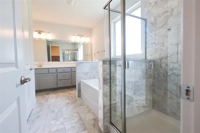 a bathroom with a granite countertop sink mirror and bathtub