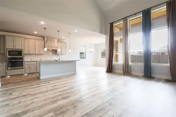 a view of a kitchen with stainless steel appliances wooden floor and a large window