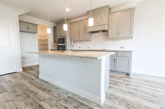 a kitchen with stainless steel appliances granite countertop a sink and a stove
