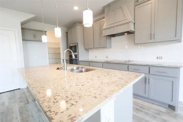 a kitchen with sink cabinets and wooden floor