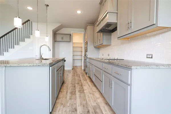 a kitchen with granite countertop a sink and a stove