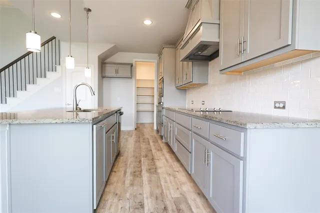 a kitchen with granite countertop a sink and a stove