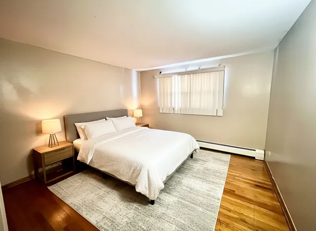 a bedroom with a bed and wooden floor