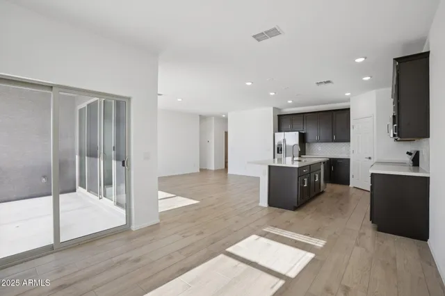 a large open kitchen with a refrigerator a sink and a microwave