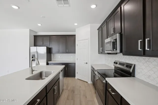 a kitchen with stainless steel appliances granite countertop a sink stove and refrigerator