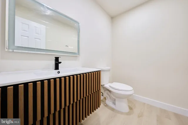 a view of kitchen with kitchen island a sink wooden floor and white cabinets