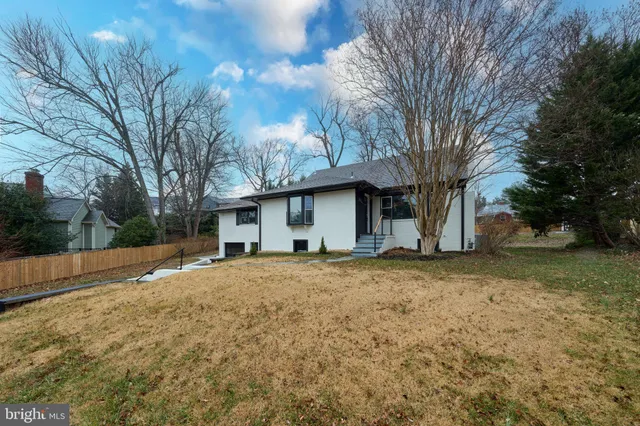 a living room with furniture a rug and white walls