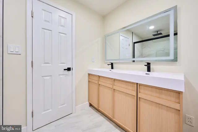 a view of a kitchen with white cabinets and a sink