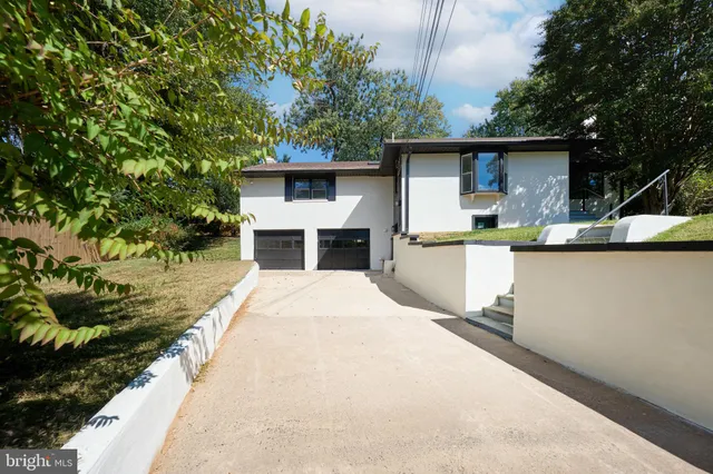 a view of an empty room with wooden floor and stairs