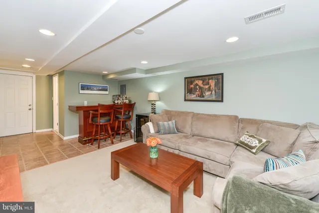 a living room with furniture and a dining table with wooden floor