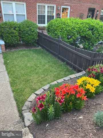 a view of a garden with flowers and wooden fence