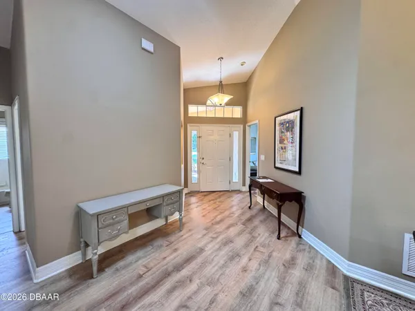 a view of a hallway with wooden floor and cabinet