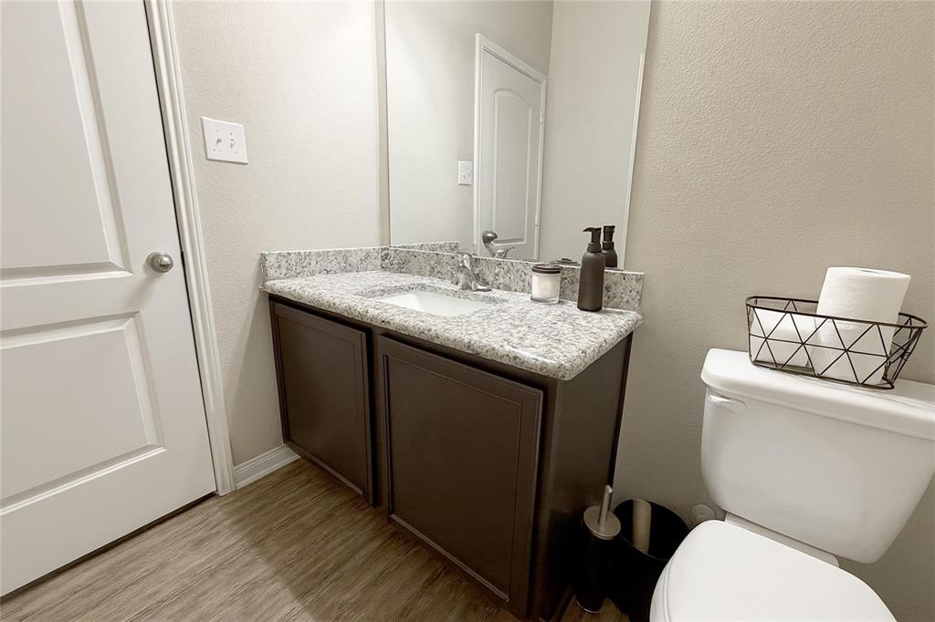 1837 Rialto Lane Crowley, TX 76036 - Photo 12 of 19 Bathroom vanity featuring a granite-style countertop, undermount sink, and wood-finish cabinetry
