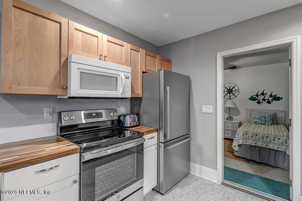 5437 3rd Street St. Augustine, FL 32080 - Photo 15 of 35 a kitchen with stainless steel appliances granite countertop a refrigerator stove and sink
