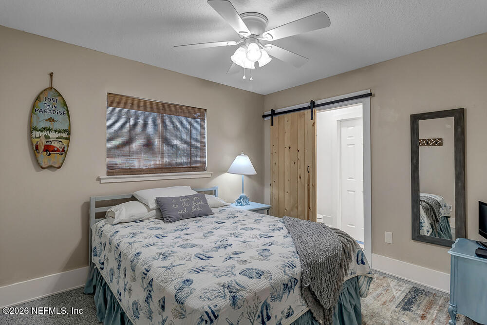 5437 3rd Street St. Augustine, FL 32080 - Photo 22 of 35 a bedroom with a bed and a chandelier