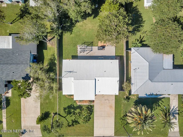 an aerial view of a house with a yard and large trees