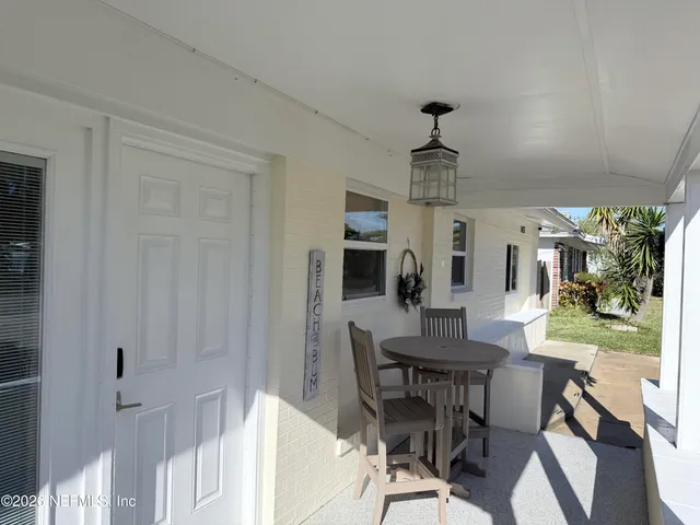 a dining room with wooden floor a chandelier a wooden table and chairs