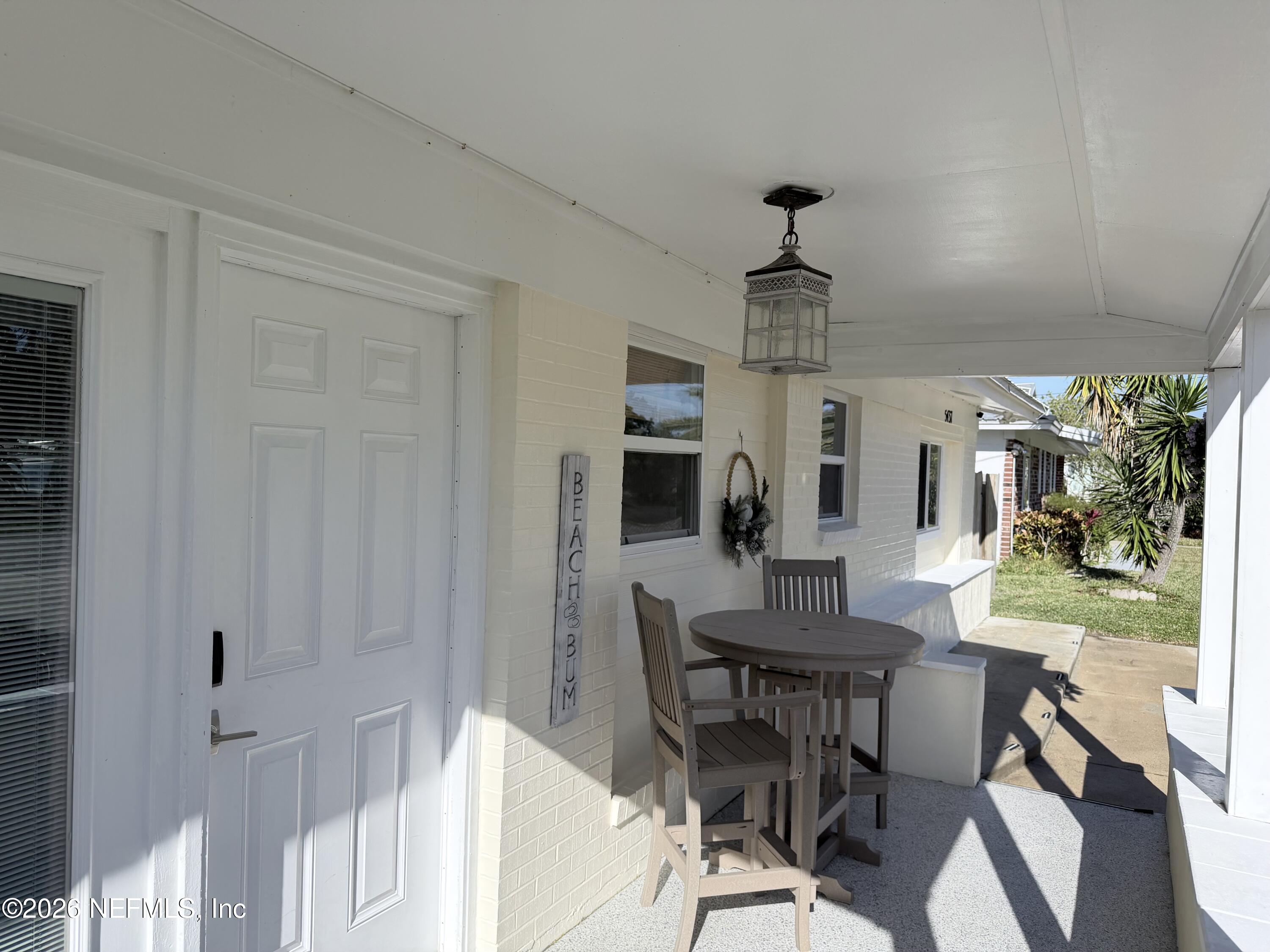 5437 3rd Street St. Augustine, FL 32080 - Photo 6 of 35 a dining room with wooden floor a chandelier a wooden table and chairs