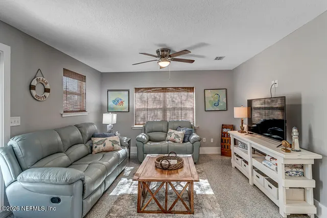 a living room with furniture a flat screen tv and a window