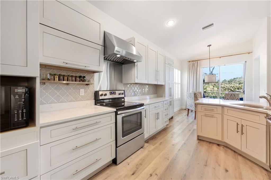 1777 Marsh Run Naples, FL 34109 - Photo 9 of 34 a kitchen with stainless steel appliances white cabinets and wooden floors
