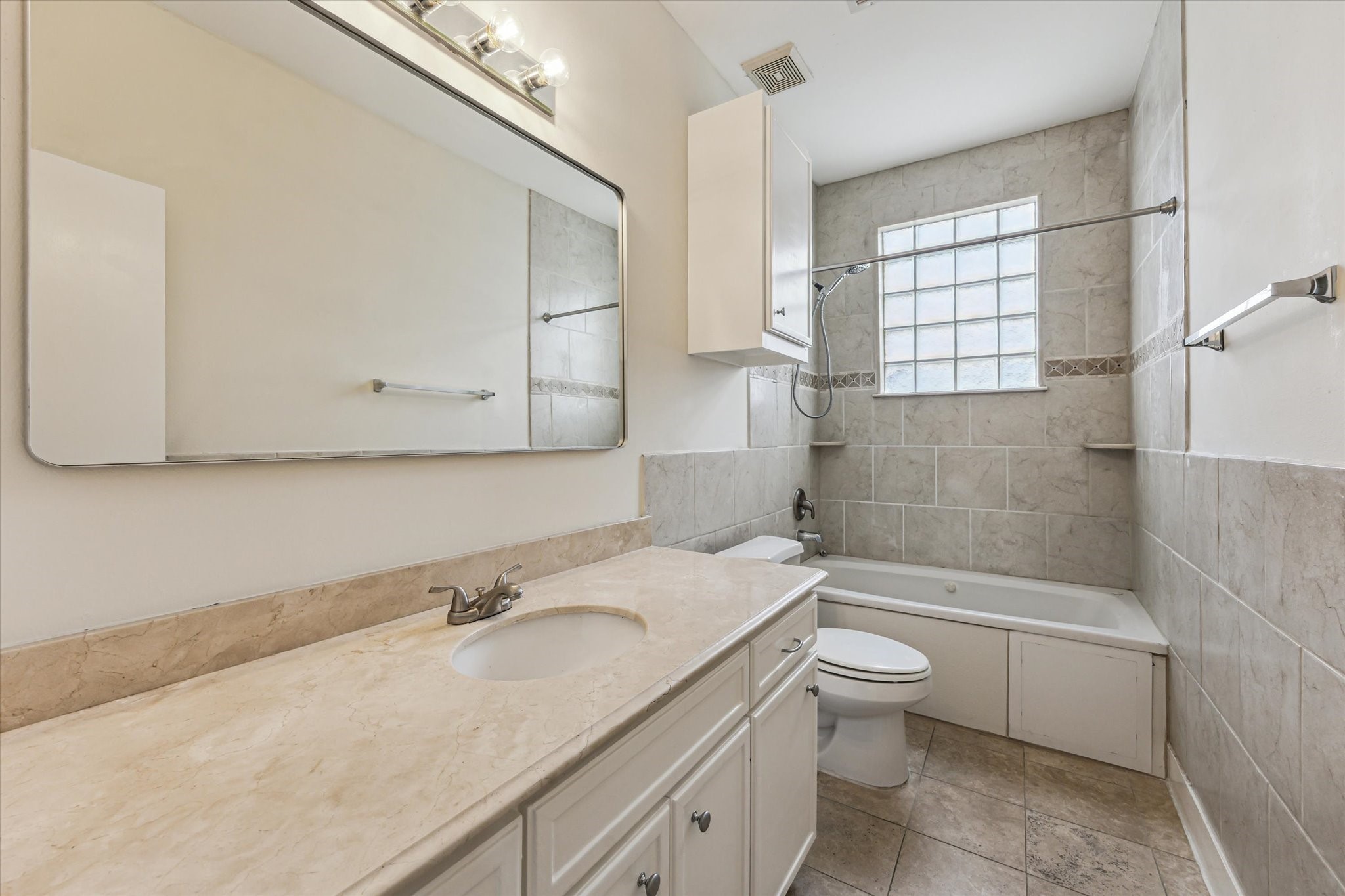 9829 Riddlelink Lane Houston, TX 77025 - Photo 16 of 22 Bright, updated full bath with tile surround, soaking tub/shower combo, and modern finishes.