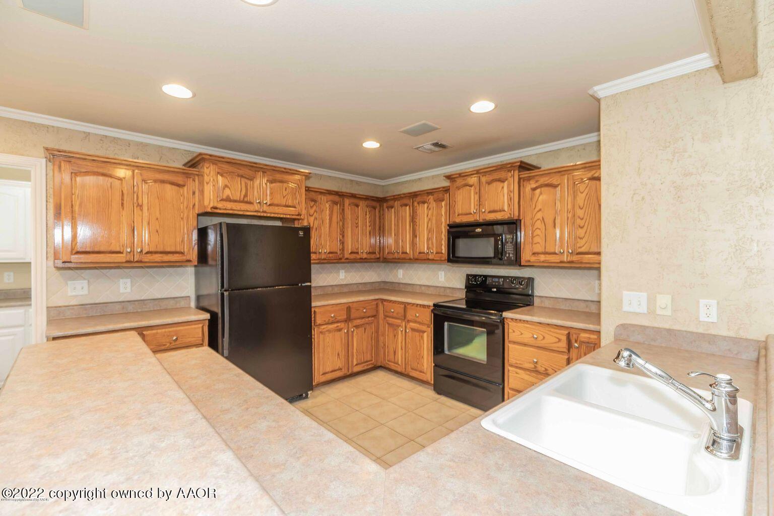 5801 South Rusk Street Amarillo, TX 79118 - Photo 5 of 27 a kitchen with a refrigerator and a stove top oven