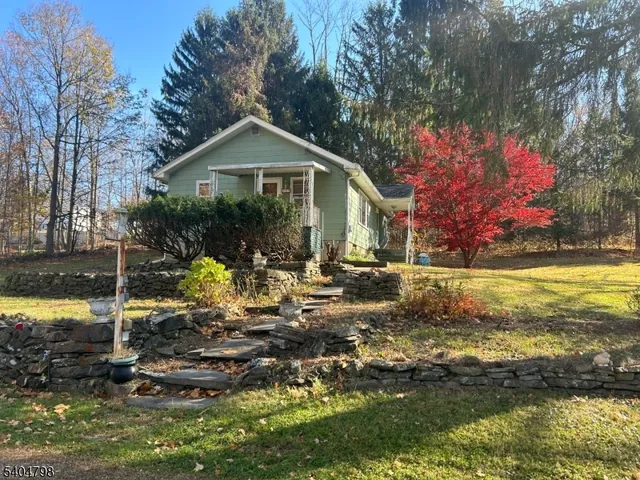 a front view of house with yard and trees in the background