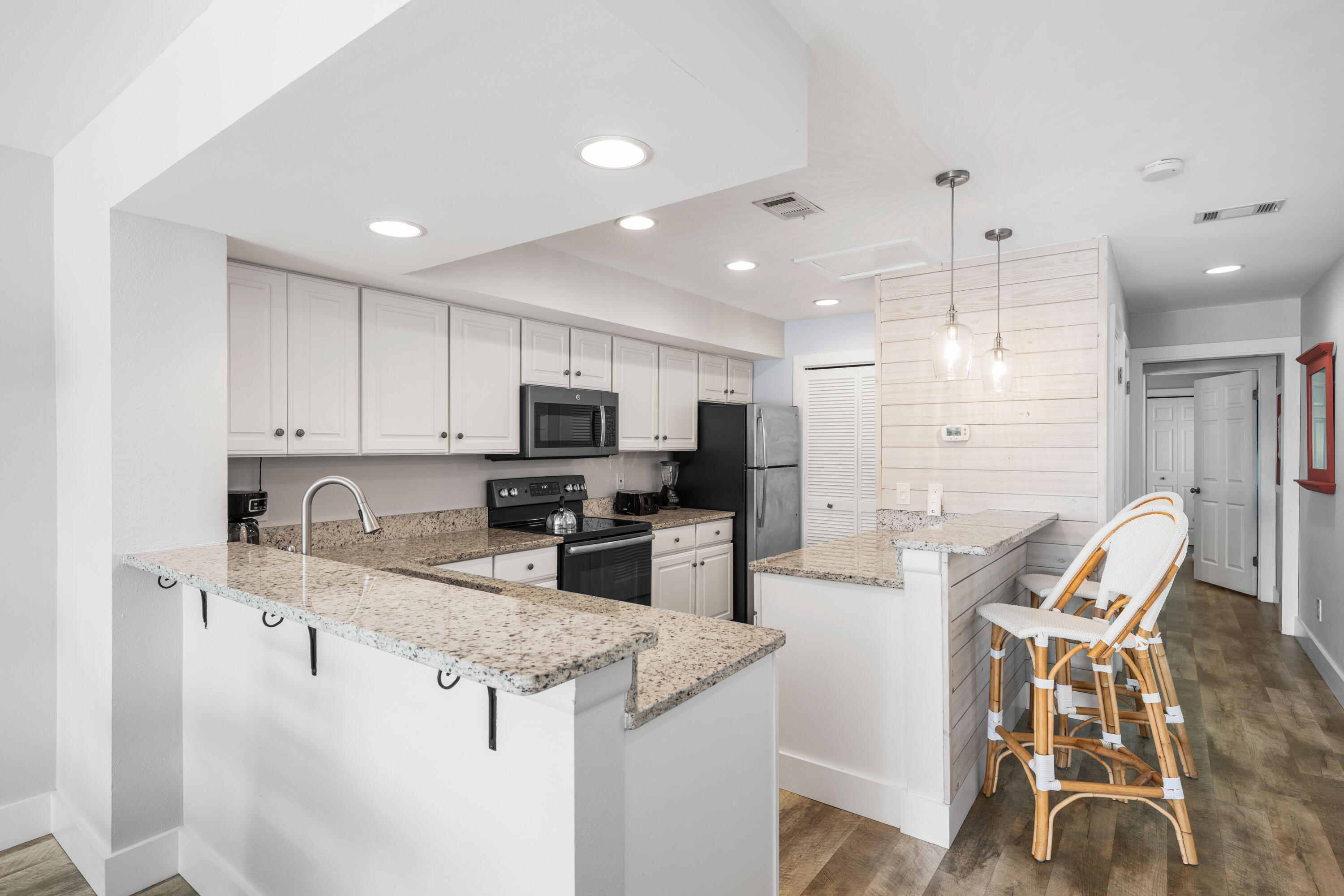 911 Harbour Point Lane, Unit 911 Miramar Beach, FL 32550 - Photo 8 of 40 a kitchen with stainless steel appliances granite countertop a sink a stove a refrigerator cabinets and chairs