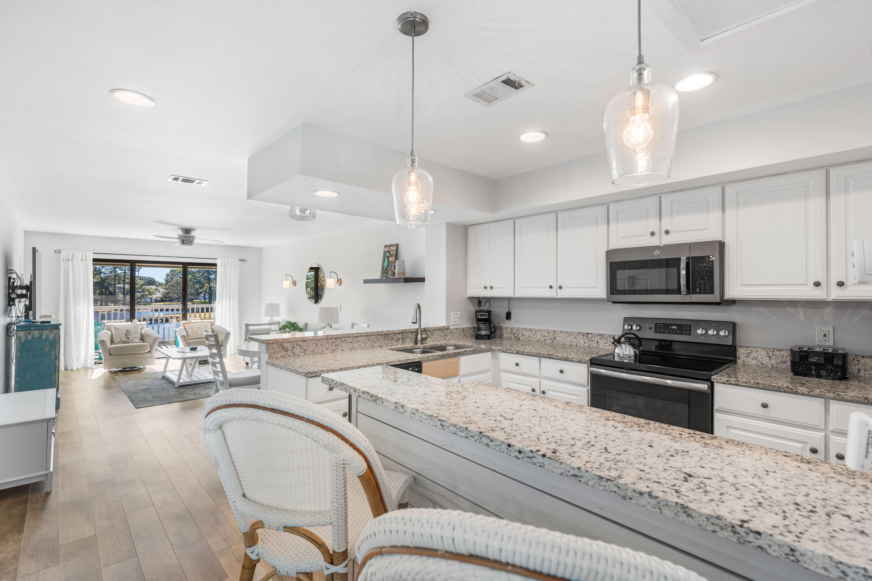 911 Harbour Point Lane, Unit 911 Miramar Beach, FL 32550 - Photo 9 of 40 a kitchen with stainless steel appliances granite countertop a stove sink and cabinets