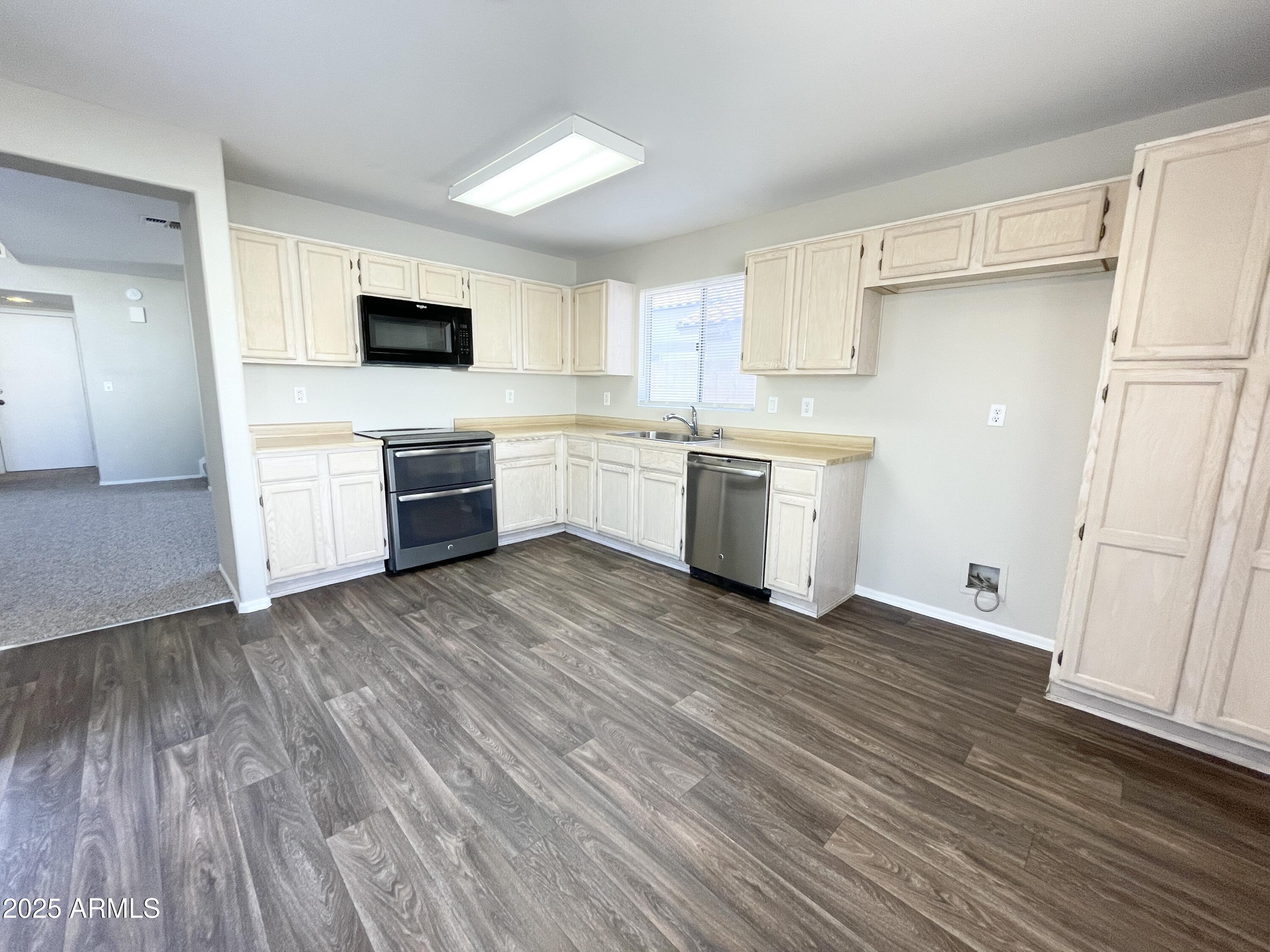 14452 South 43rd Street Phoenix, AZ 85044 - Photo 11 of 33 a kitchen with a sink wooden floor and stainless steel appliances