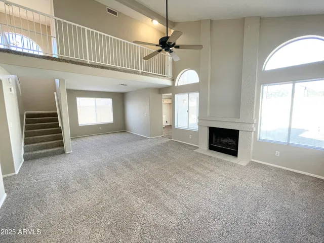 a view of an empty room with a fireplace and a window