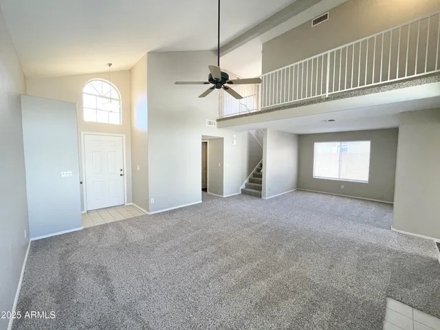 a view of a big room with chandelier fan and windows