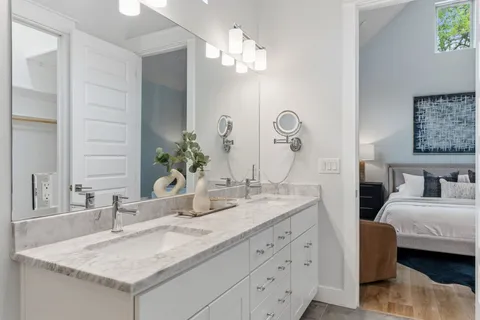 a bathroom with a granite countertop sink a large mirror and a bathtub