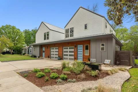 a living room with furniture fireplace and large windows