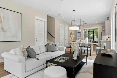 a dining room with wooden floor a chandelier fan a wooden table and chairs