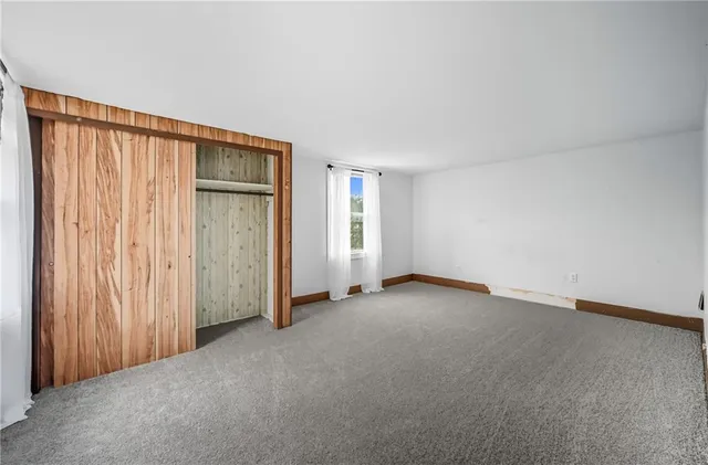 an empty room with windows and closet