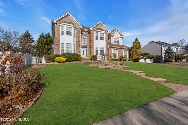 a front view of a house with a garden and yard