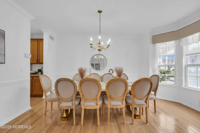 a dining room with furniture a chandelier and wooden floor