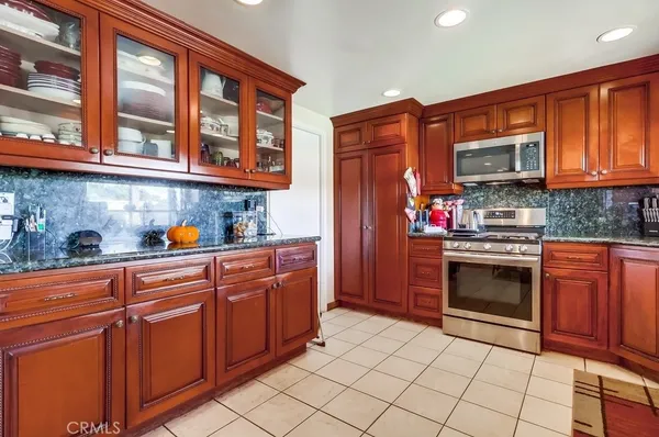 a kitchen with stainless steel appliances granite countertop a refrigerator and a stove top oven