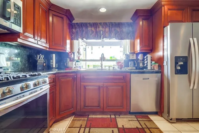 a kitchen with stainless steel appliances granite countertop a stove sink and cabinets