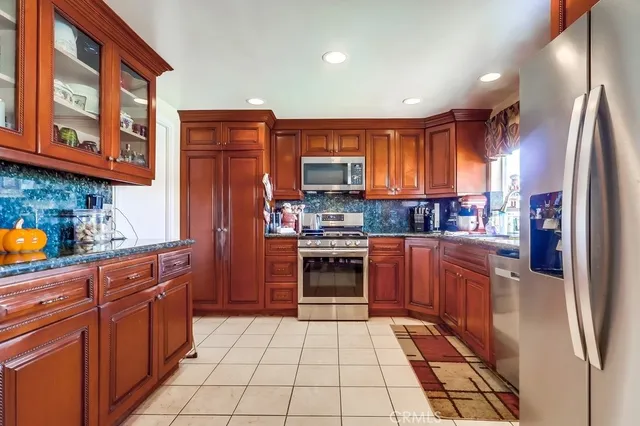 a kitchen with stainless steel appliances granite countertop a refrigerator and a stove top oven