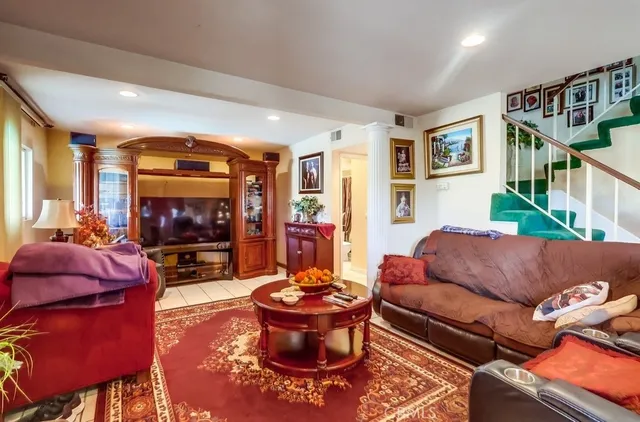 a living room with furniture a flat screen tv and a floor to ceiling window