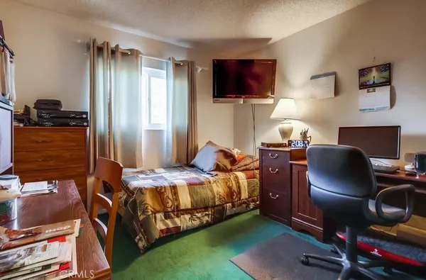 a bedroom with a bed dresser and a window