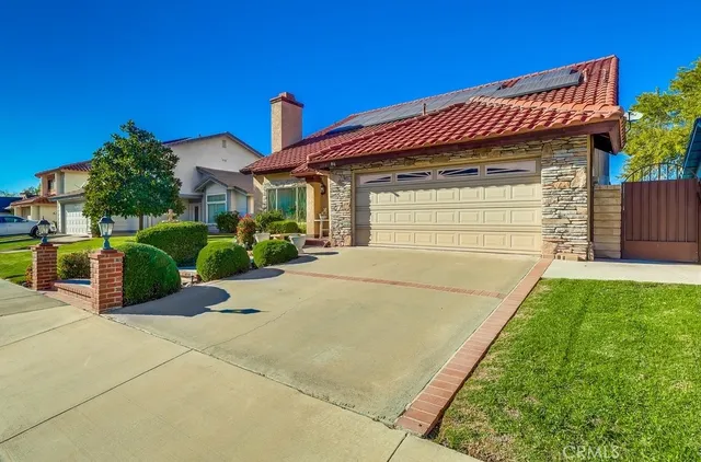 a front view of a house with a yard and potted plants